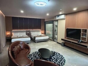 A modern hotel room with two beds, a TV, a sofa, and a shower area. - Skyport Hotel (Parañaque)