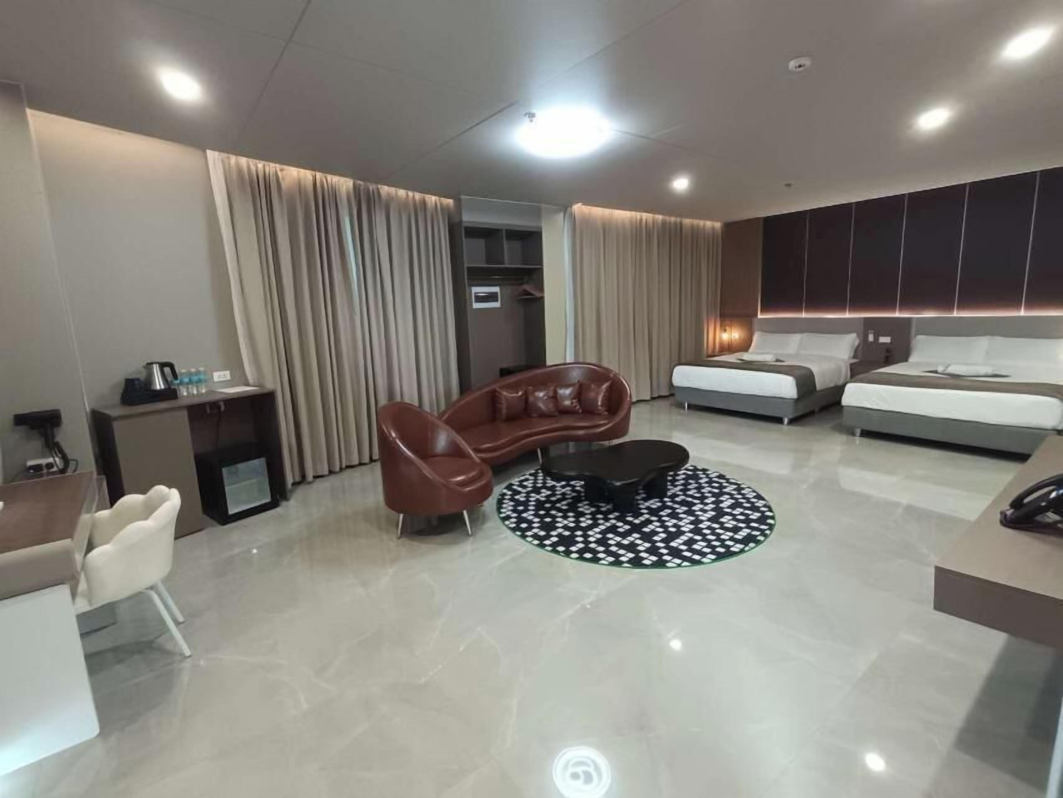 A modern hotel room with a sofa, a coffee table, a dining table, and a bed.