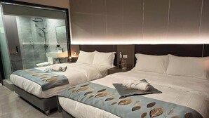 A hotel room with two beds, a shower area, and a large mirror. - Skyport Hotel (Parañaque)