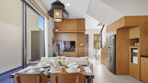 Eine moderne Küche mit Holzsärchen, einem eingebauten Kühlschrank und einem Essbereich mit Tisch für vier Personen.
