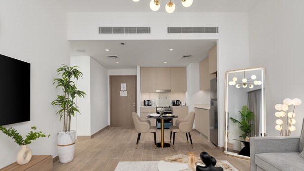 Una sala moderna con un televisor de pantalla plana, una zona de comedor con una mesa redonda y una cocina al fondo.