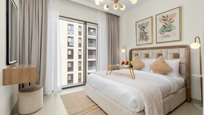 Una habitación de hotel moderna con una cama grande, una mesita de noche, un televisor y vistas a la ciudad.