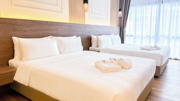 A hotel room with two beds, white bedding, and neatly folded towels on the beds. - Cottonhouz, KK Times Square by Ayuhouz (Kota Kinabalu)