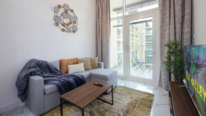 A modern living room with a grey sofa, a wooden coffee table, and a decorative wall piece.