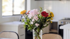 Et spisebord med en blomstervase, et lys og en trækasse.