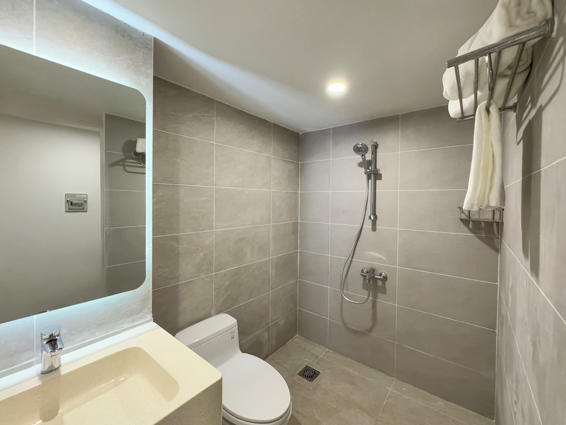 A modern bathroom with a toilet, sink, and shower.
