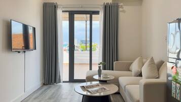 Departamento Deluxe | Área de sala de estar | Televisión LCD de 43 pulgadas con canales por cable y Netflix