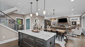 A spacious living area with a large island, a fireplace, and a TV mounted above it. - Western Ridge Lookout at Blue Ridge Mountain Club - community amenities with seasonal pool (Boone)