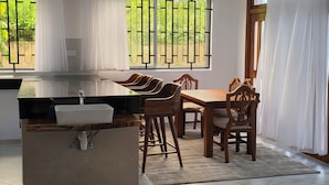 Une cuisine moderne avec un évier blanc, des chaises en bois et une table à manger.