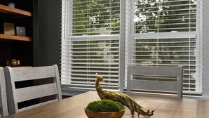 A dining area with a wooden table, chairs, a bowl with green plants, and a golden sculpture. - Sleeps 5 _ 2bedroom Home in Overland Park! (Overland Park)
