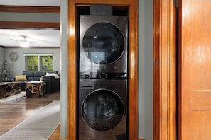 Een moderne wasruimte met een wasmachine en droger met dubbele deuropening.