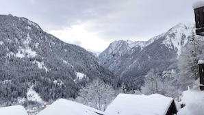 A mountainous landscape with snow-covered trees and a cabin with a wooden balcony. - 6-8 person apartment at the foot of the lifts, in a typical village (Champagny-en-Vanoise)