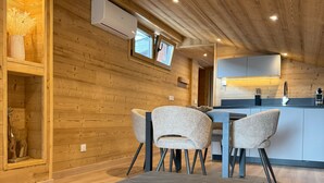 Un intérieur moderne avec des murs en bois, une table basse en pierre et un coin cuisine.