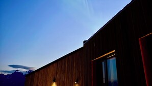 Un edificio con fachada de madera y una ventana que ofrece vistas del cielo.
