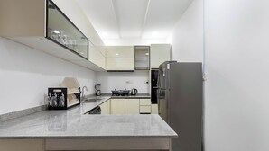 Una cucina moderna con piano di lavoro in granito, elettrodomestici in acciaio inox e forno integrato.