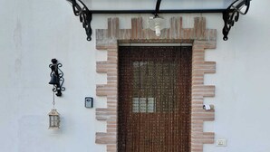 Una entrada de edificio con una reja de metal, un farol y un buzón.