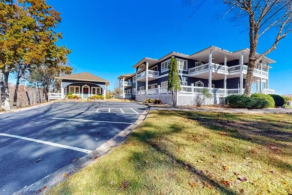 A multi-story hotel with a central courtyard, balconies, and a parking lot. - The Ellijay Resort (Ellijay)