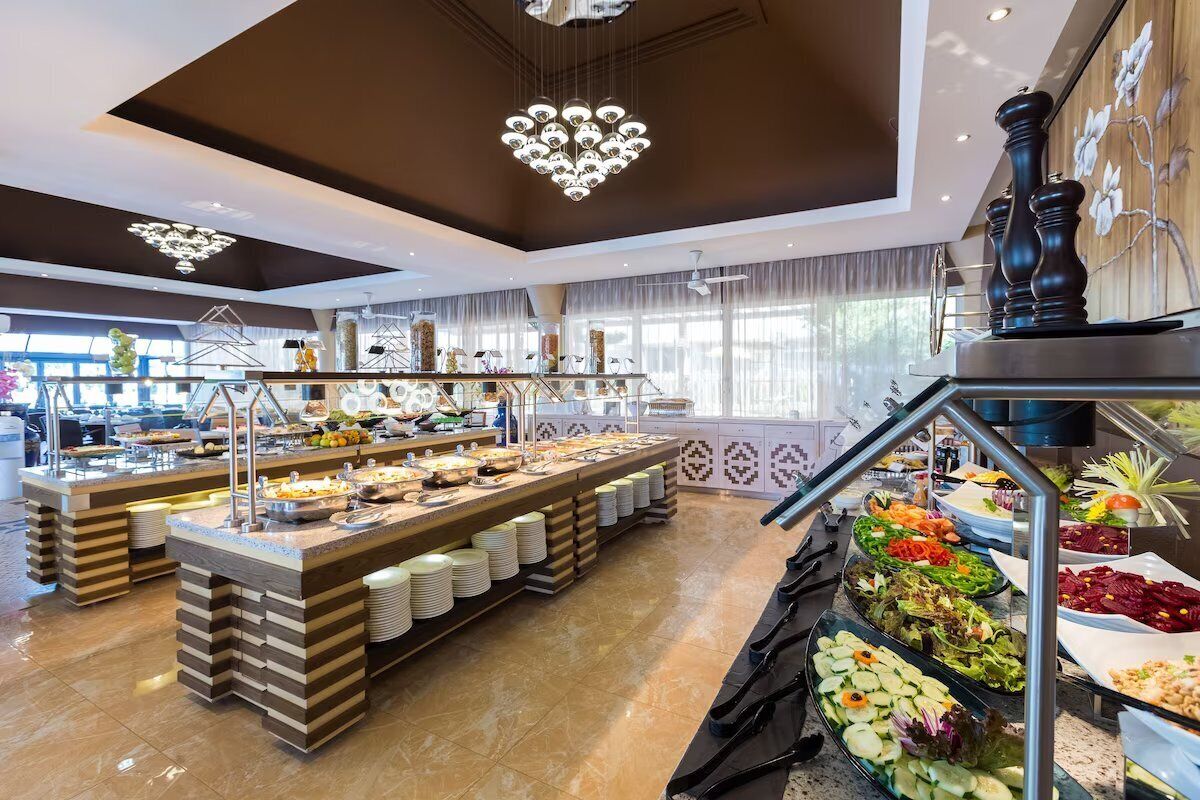 Een buffetopstelling met meerdere themastations, waaronder salades, fruit en diverse gerechten.
