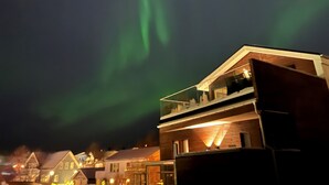 A modern building with a balcony and a view of the night sky.