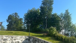 A paved area with a stone retaining wall and a lamp post.
