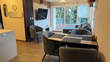 A modern living room with a sofa, a coffee table, and a TV mounted on the wall.