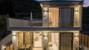 A modern two-story house with a dining area, kitchen, and living spaces.
