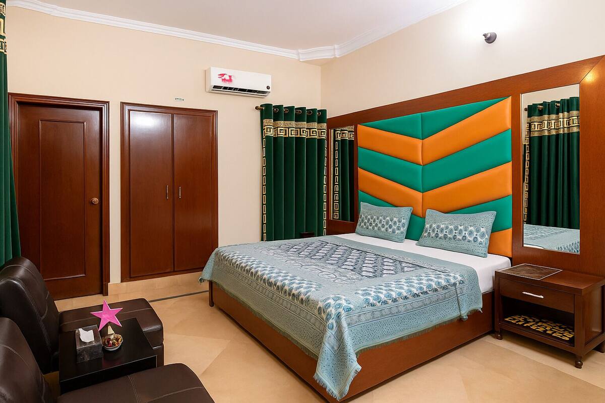 A bedroom with a bed, a nightstand, a dresser, and a wardrobe.
