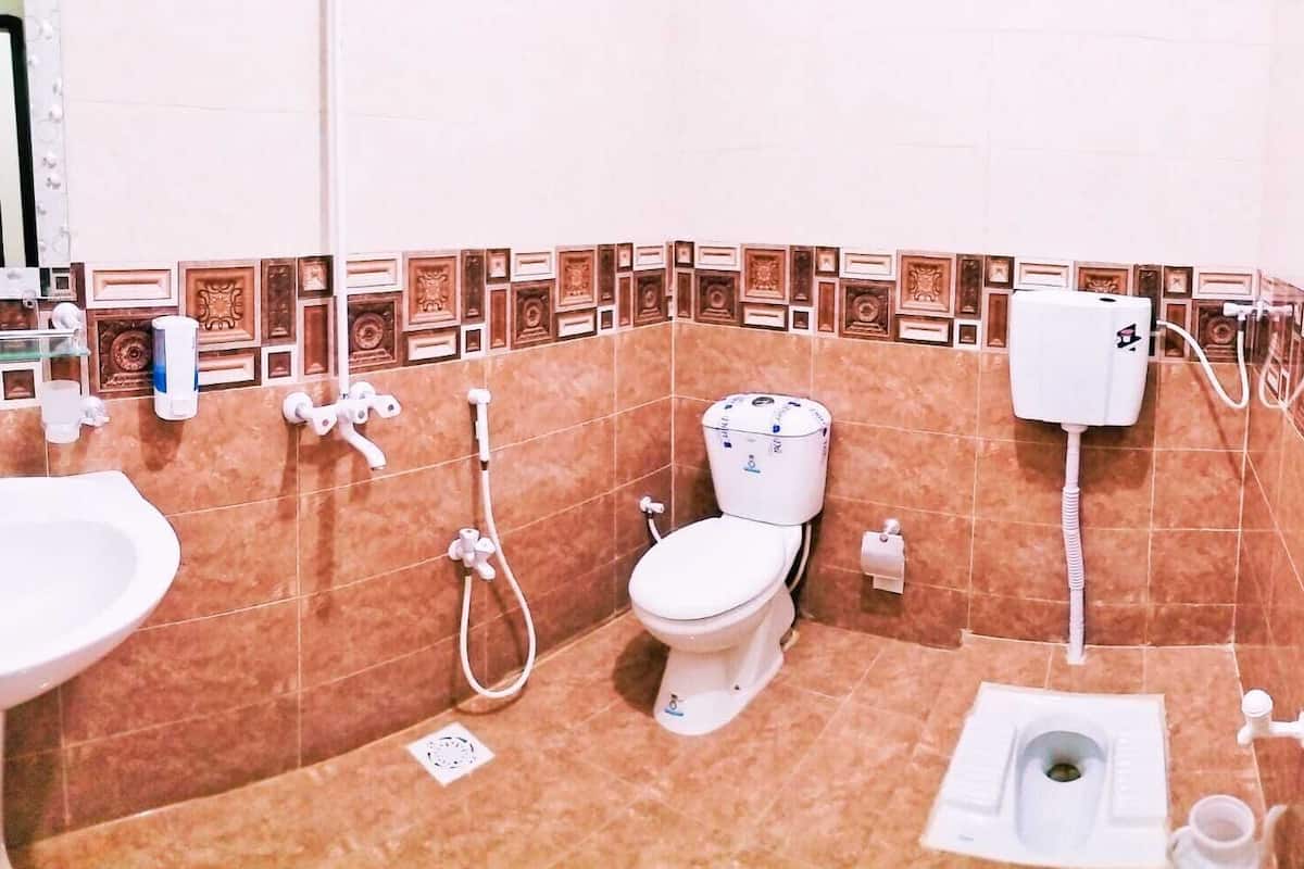A bathroom with a toilet, bidet, and sink.