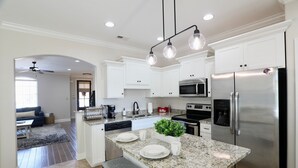 A modern kitchen with white cabinets, stainless steel appliances, and a granite countertop. - "Swayze Stays" - Charming Oxford Condo! (Oxford)