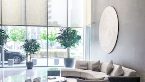 Um hall moderno com uma grande área de estar, uma mesa de centro e duas plantas em vasos.