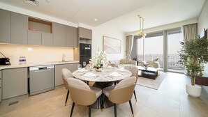 Uma cozinha moderna com armários cinza, lava-louças embutida e um espaço de refeições com mesa e cadeiras redondas.