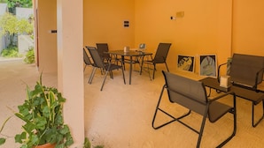 A room with a table and chairs, a ceiling fan, and potted plants. - Ari Stay Thoddoo  (Thoddoo)