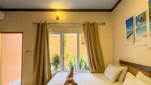 A hotel room with two beds, a ceiling fan, a window with curtains, and a view of the outdoors. - Ari Stay Thoddoo  (Thoddoo)
