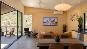 Ein modernes Interieur mit Essbereich, großem Fenster und Deckenventilator.