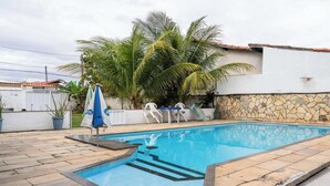 Ein rechteckiger Swimmingpool mit Steinmauer und gefliestem Beckenrand.