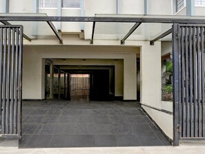Una entrada protegida por una reja a un edificio con piso de baldosas y un camino despejado que lleva a una puerta interior.