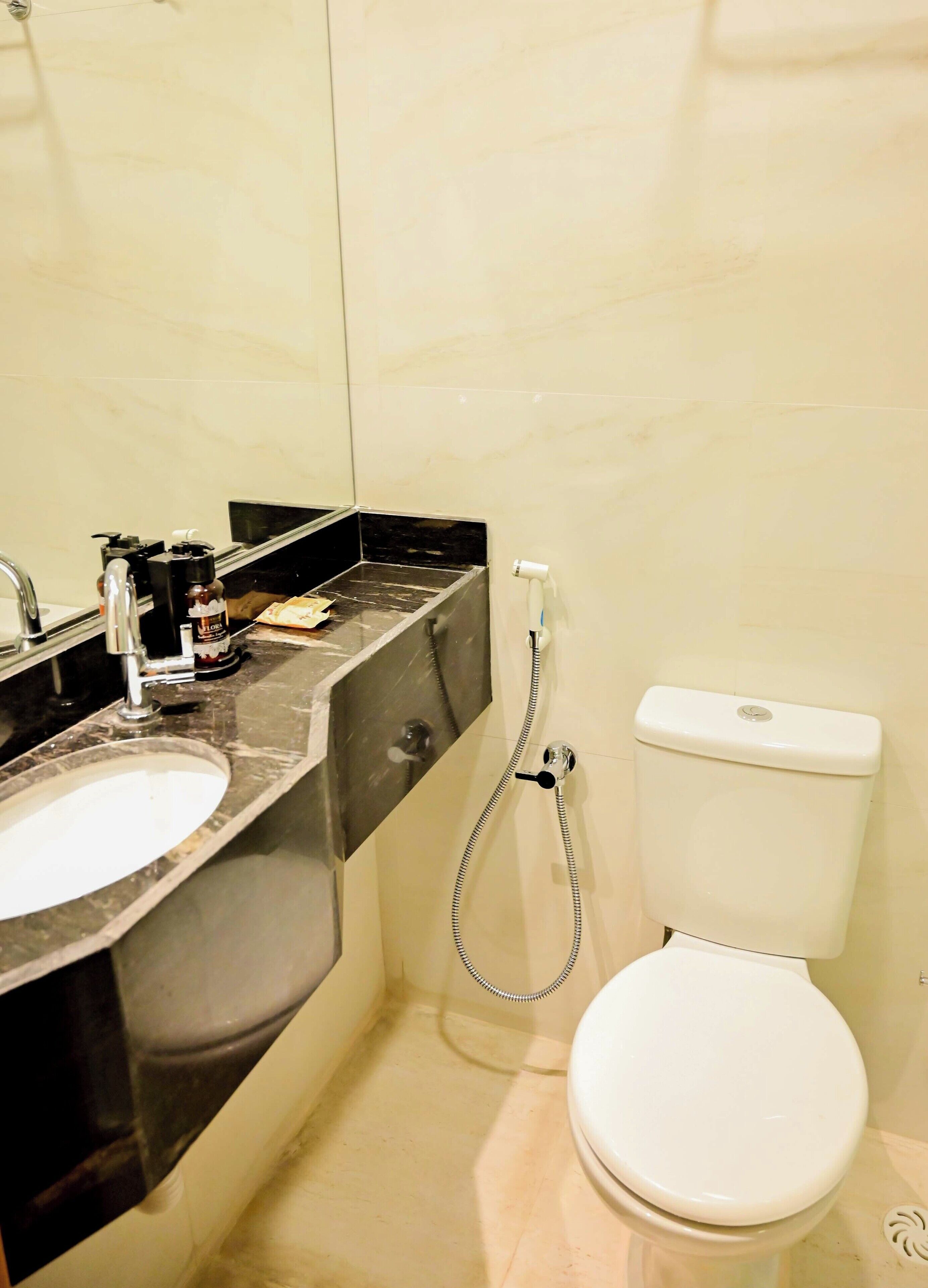 A bathroom with a white toilet, a sink, and a shower.