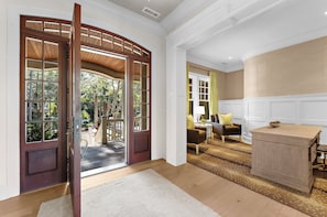 A room with a wooden door, a sofa, a lamp, and a wooden cabinet.