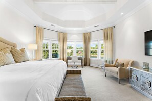 Ein Schlafzimmer mit einem groĂen Bett, einem Schreibtisch, einem Stuhl und einem Fernseher.