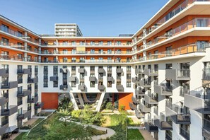 A multi-story residential building with balconies, a central courtyard, and a modern architectural design.