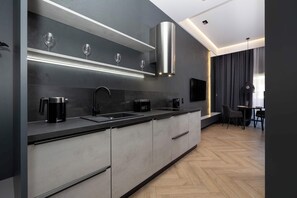 A modern kitchen with a built-in stove, a coffee maker, and a flat-screen TV.