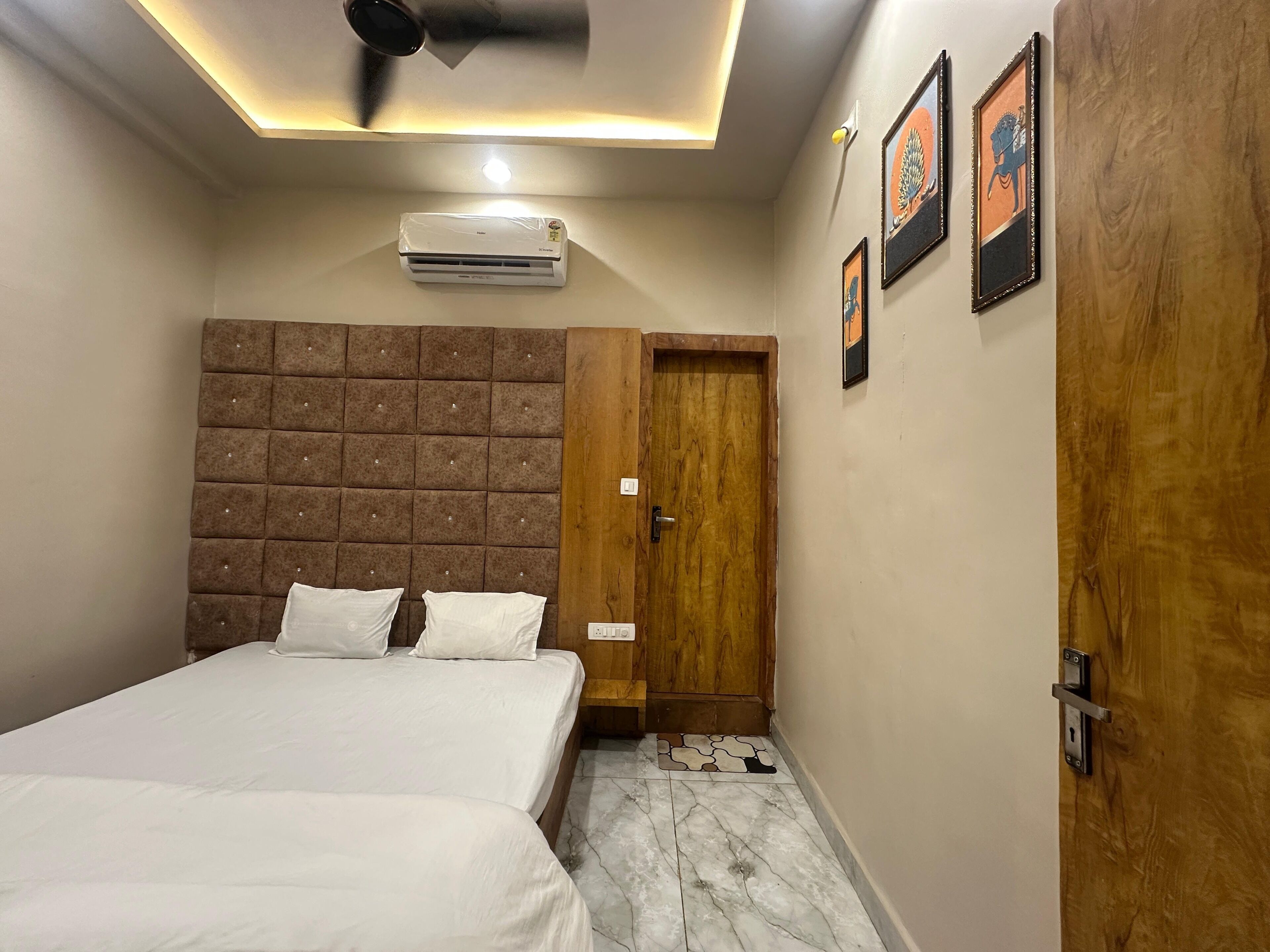 Une chambre à coucher avec un lit, une porte en bois et un ventilateur de plafond.