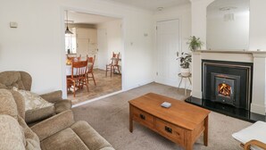 A living room with a fireplace, a dining area, and a kitchen in the background. - Dunbrody Dreams (Campile)
