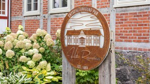 A circular sign with a building illustration, the text 'Entschelung Pur' and 'Hof Rosenthal' with the establishment year '1885'. - Apartment '1' with Private Terrace, Shared Garden and Wi-Fi (Groß Pankow)
