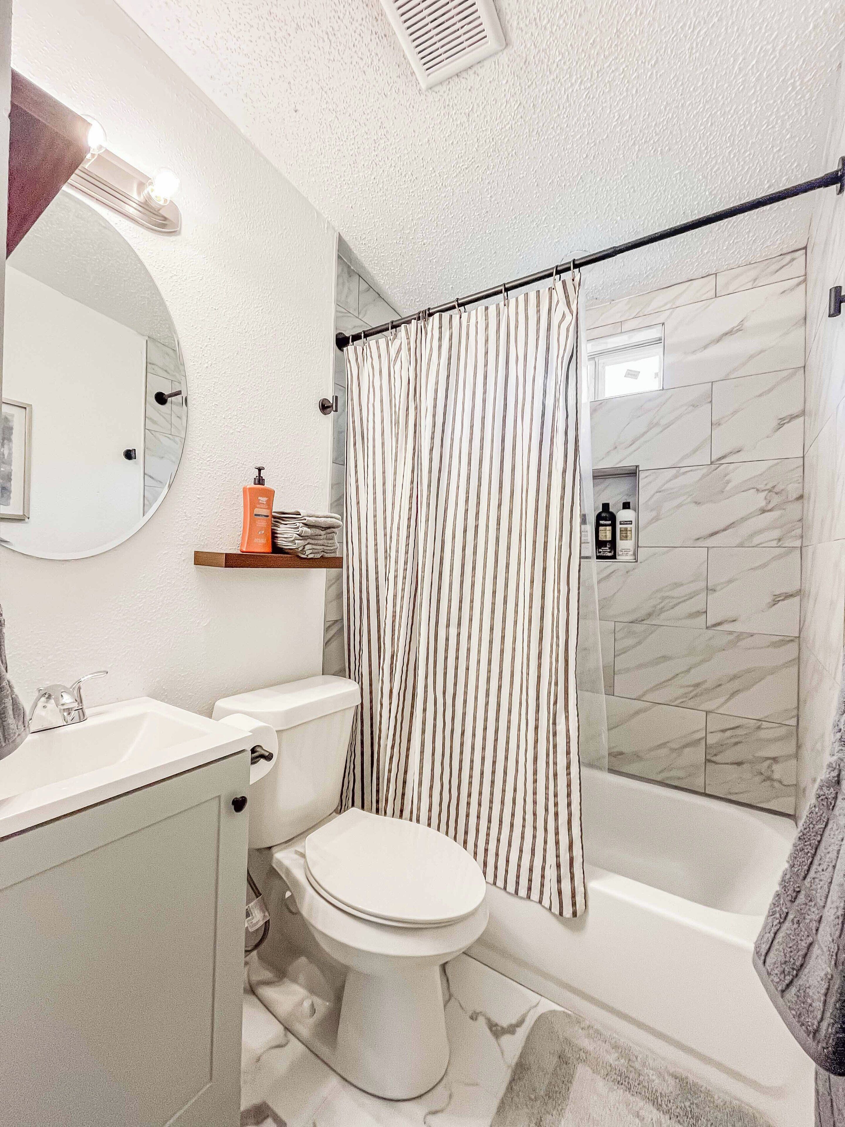 A bathroom with a toilet, sink, and shower area.