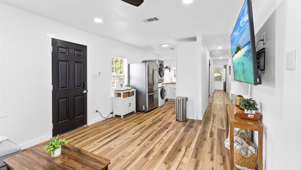 A modern kitchen with a refrigerator, oven, and washing machine.