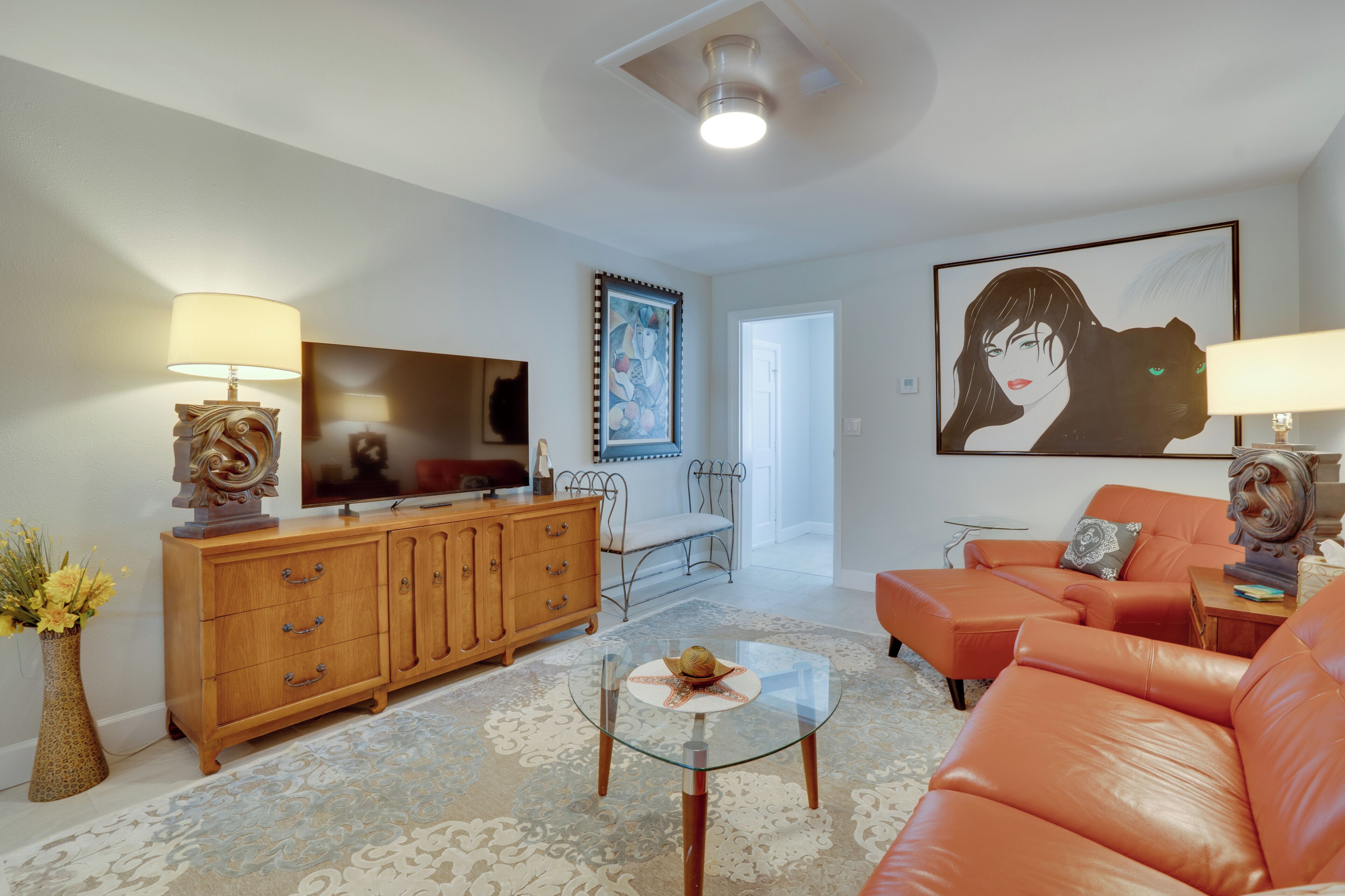 Una sala de estar con sofá, mesa de centro, televisor y mueble.