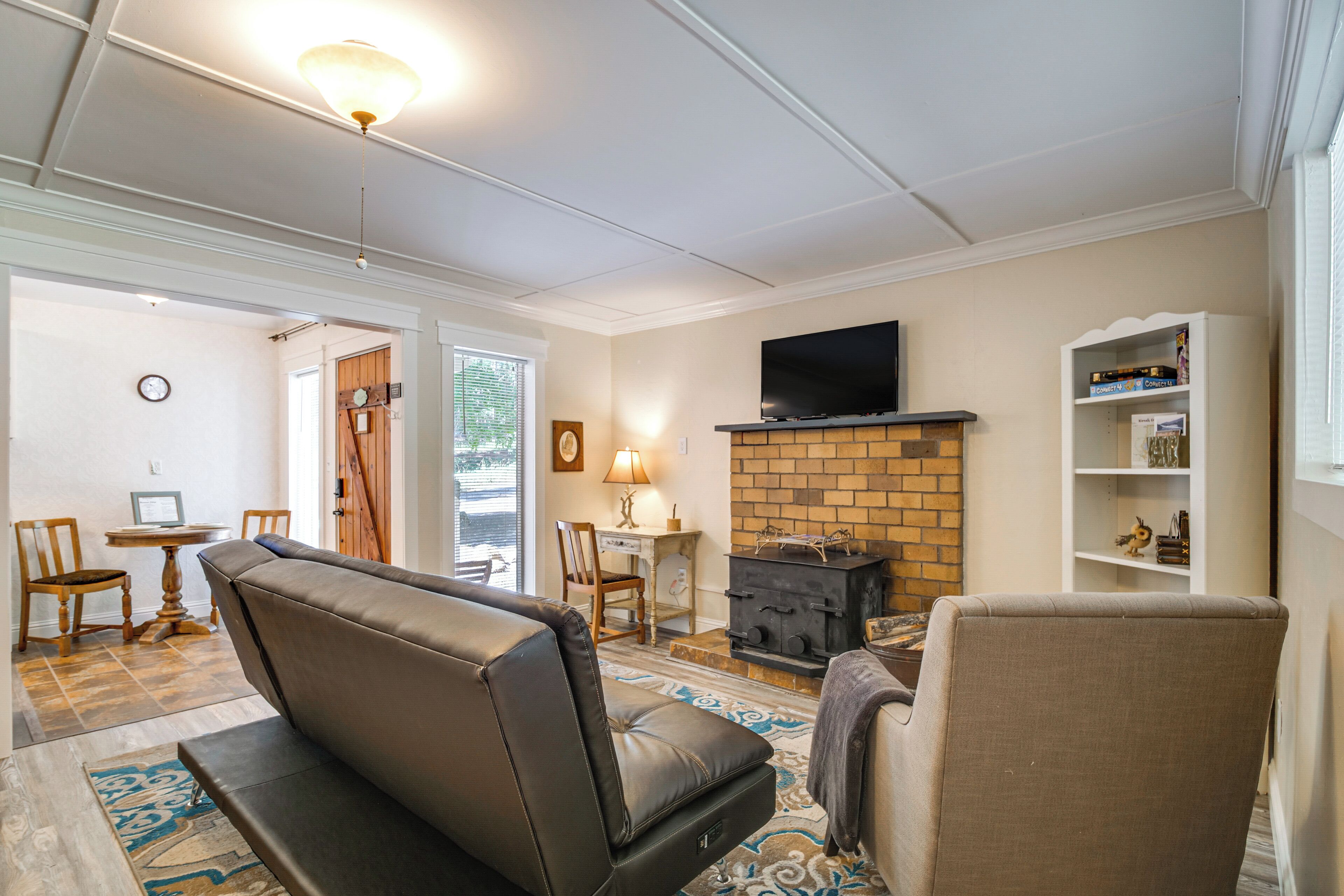 A living room with a fireplace, a television mounted above it, and a bookshelf.