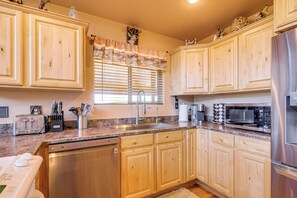A kitchen with wooden cabinets, a stainless steel refrigerator, a microwave, and a dishwasher. - Luxe Cabin Retreat, Near Bryce & Zion Nat'l Parks! (Duck Creek Village)