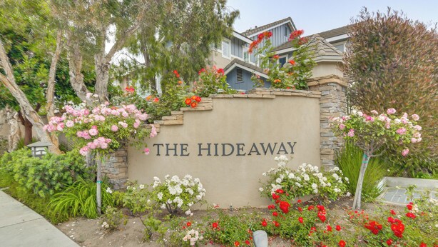 A sign with "THE HIDEAWAY" written on it, surrounded by a garden with various flowers and plants. - Walk to Beach: Luxe San Buenaventura Villa! (Port Hueneme)